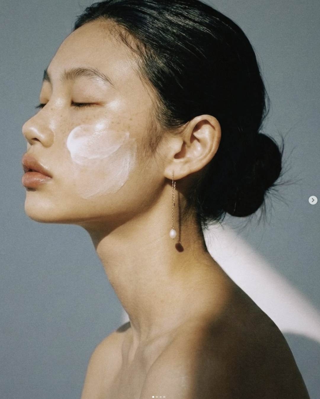Model with sunscreen applied to her cheek in soft daylight